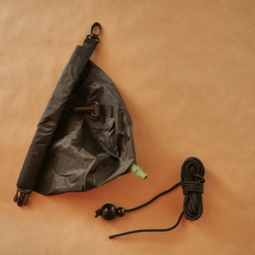 Worek prysznicowy o pojemności 7 litrów wraz ze sznurkiem z obciążnikiem, który ułatwia zamontowanie go w plenerze, np. na gałęzi.